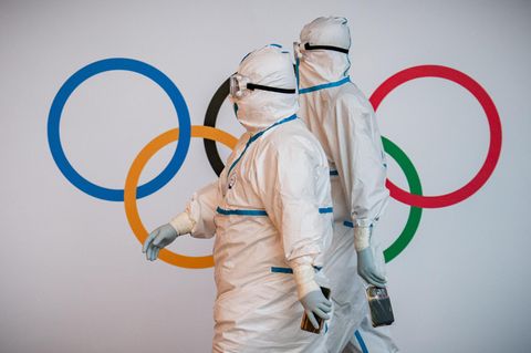 Olympia 2022 in Peking: In kompletter Schutzmontur empfangen Helfer am Flughafen in Peking die Teilnehmenden der Winterspiele.