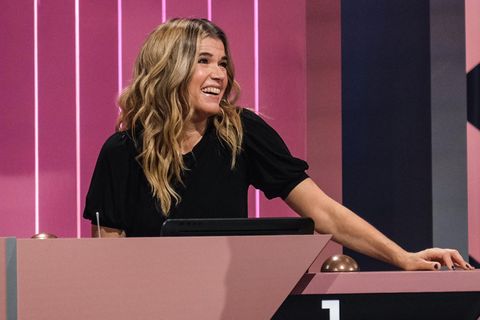 Anke Engelke sitzt im Studio von "Wer stiehlt mir die Show" an einem Pult und lacht.