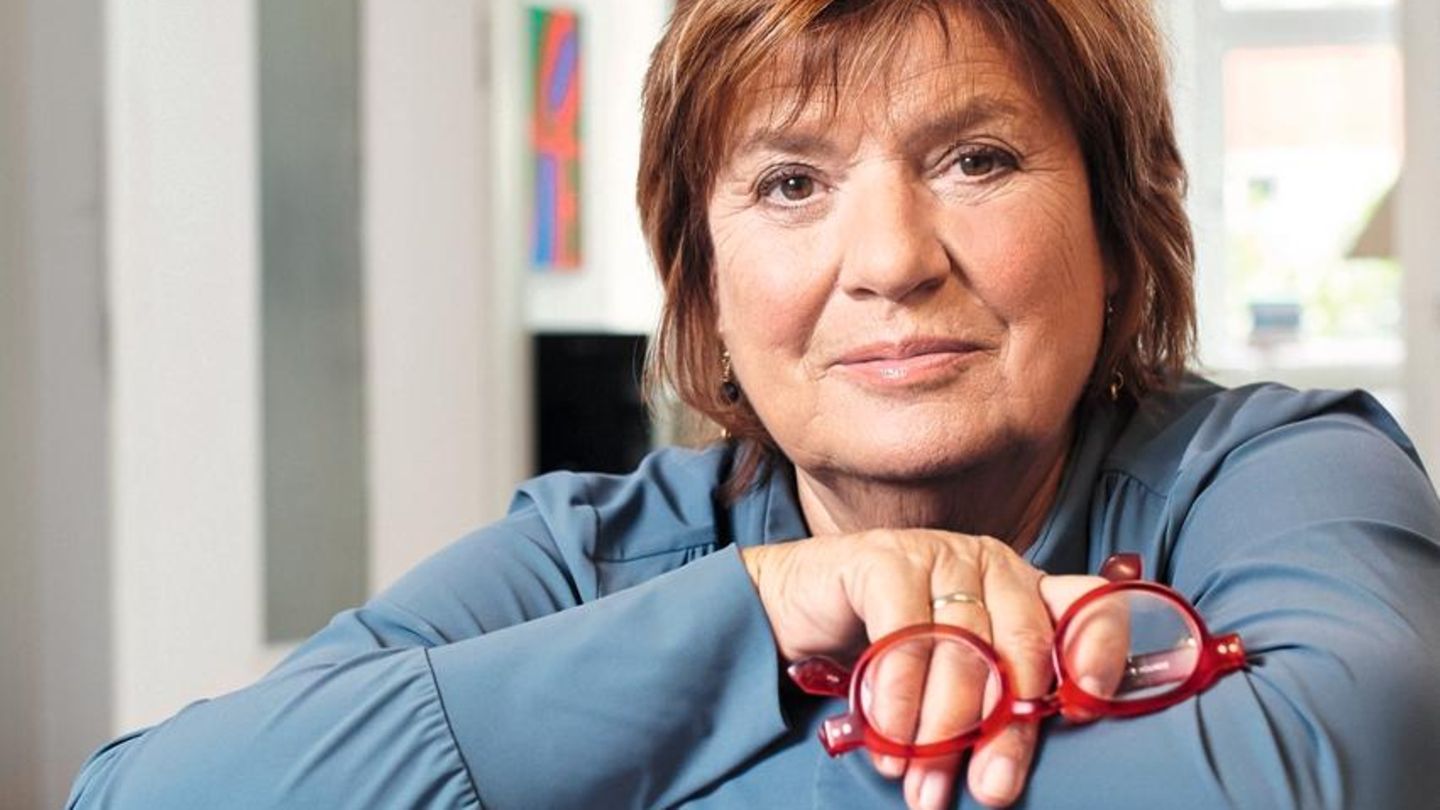 Christine Westermann lehnt sich auf einen Stapel Bücher