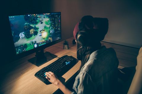 Eine Frau spiel am 32-Zoll-Monitor ein Computerspiel.