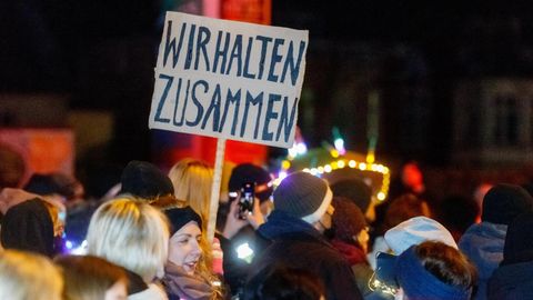Demonstranten halten ein Schild hoch