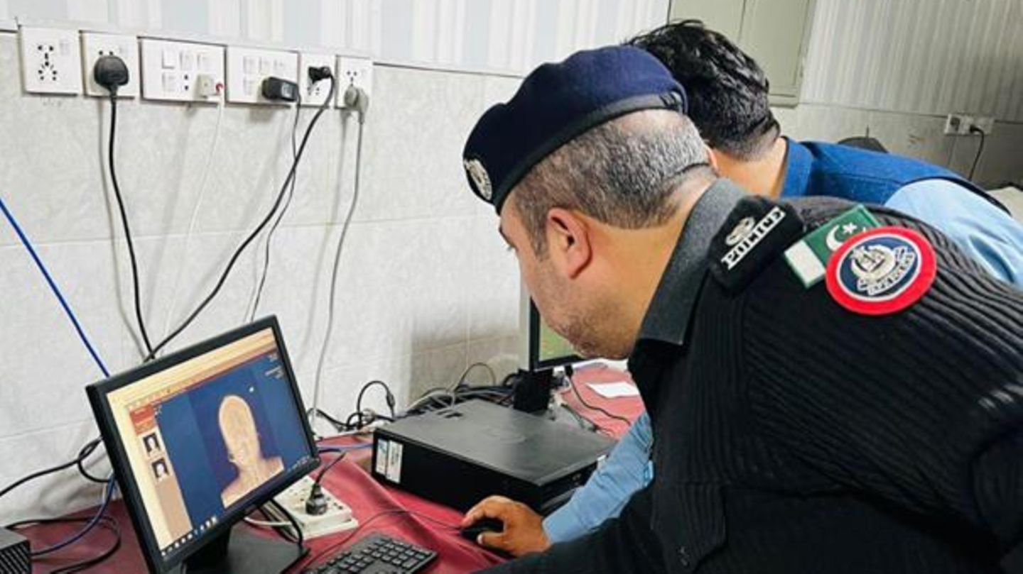 Polizisten untersuchen das Röntgenbild der Schwangeren