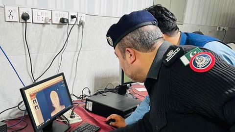 Polizisten untersuchen das Röntgenbild der Schwangeren