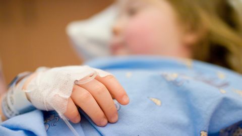 Ein kleiner Junge liegt in einem Krankenhausbett