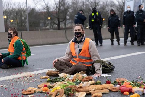 Klimaaktivist sitzt auf der Fahrbahn der Autobahn A100