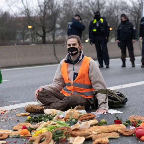 Klimaaktivist sitzt auf der Fahrbahn der Autobahn A100