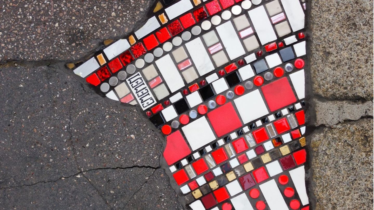 Wo früher Risse und Gras im Boden waren, findet sich jetzt Streetart in Form von kleinen Steinchen