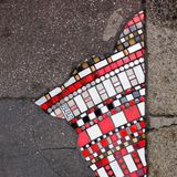 Wo früher Risse und Gras im Boden waren, findet sich jetzt Streetart in Form von kleinen Steinchen