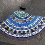 Kleine Steine sind im Halbrund auf einem Straßenbelag angebracht