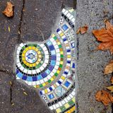 Kleine Steine sind im Halbrund auf einem Bürgersteig angeordnet. Früher waren hier Risse im Boden