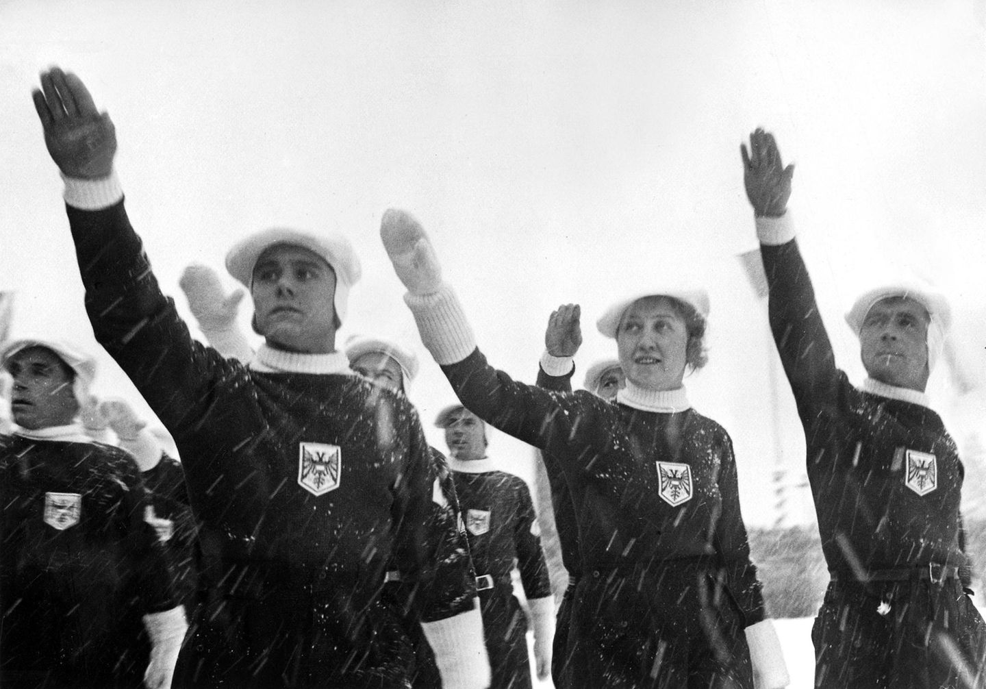 1936 Olympische Spiele in Garmisch-Patenkirchen zur Zeit des Dritten Reichs. Wie schon die Sommerspiele, so fanden auch die Winterspiele in diesem Jahr in Deutschland statt. Unter anderem wurden die Spiele von vielen politischen Gesten geprägt. Beispielsweise weigerte sich das US Eishockey Team, Hitler mit der Nazi-Parole zu begrüßen. Dieser konfrontierte die Mannschaft angeblich in der Kabine und gab schließlich nach.