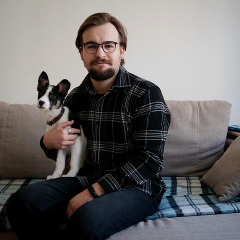 Petro Sabat mit seinem kleinen Hund auf dem Schoß