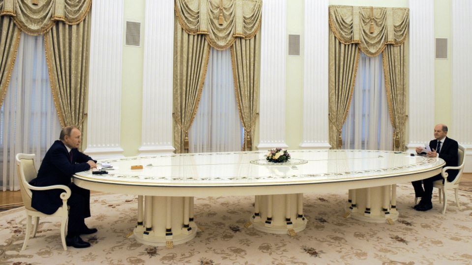 Wladimir Putin und Olaf Scholz sitzen an entgegengesetzten Enden einer langen Tafel
