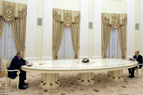 Wladimir Putin und Olaf Scholz sitzen an entgegengesetzten Enden einer langen Tafel