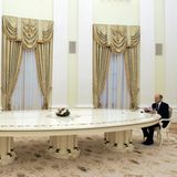 Wladimir Putin und Olaf Scholz sitzen an entgegengesetzten Enden einer langen Tafel