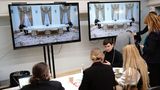 Journalisten verfolgen in einem Presseraum die Übertragung des Treffens.