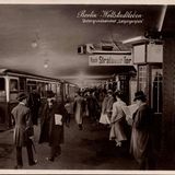 Ein Mann mit Hut liest Zeitung am Untergrundbahnhof Leipzigerplatz. Andere Menschen steigen in die U-Bahn ein. Foto von 1935.
