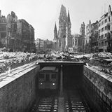 Trotz starker Beschädigungen während des Krieges ist der größte Teil der Berliner U-Bahn im Februar 1946 wieder in Betrieb. In Teilen unter freien Himmel, wie hier vor der Ruine der Kaiser-Wilhelm-Gedächtniskirche.