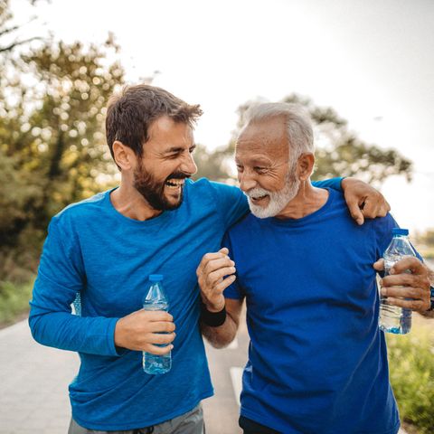 Demenz und Sport: Ein älterer und ein jüngerer Mann lachen nach dem Sporttreiben