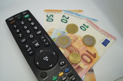 Eine Fernbedienung liegt auf Geld