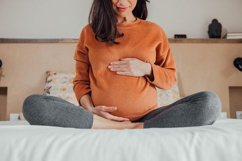 Schwangere fasst ihren Bauch an