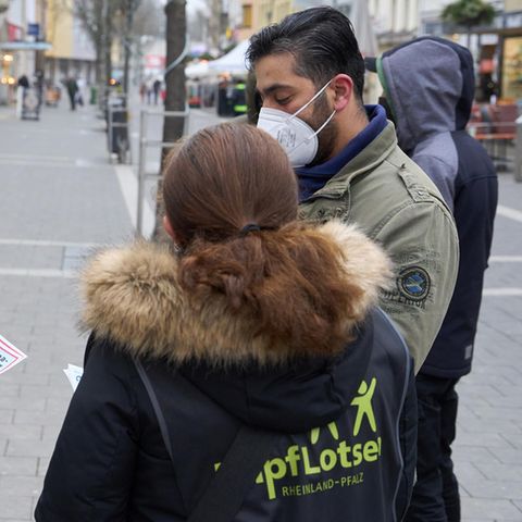 Impflotsen sprechen mit Passanten und informieren über die Corona-Schutzimpfung