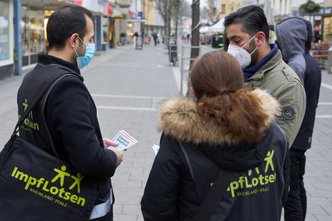 Impflotsen sprechen mit Passanten und informieren über die Corona-Schutzimpfung