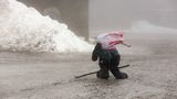 Ein junger Wanderer auf dem Brocken kämpft am Boden gegen starke Windböen