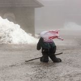Ein junger Wanderer auf dem Brocken kämpft am Boden gegen starke Windböen