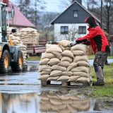 Im strömenden Regen werden Sandsäcke von freiwilligen Helfern verteilt.