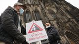 "Vorsicht Steinschlag" steht auf einem Schild, das Mitarbeiter des Doms aufstellen