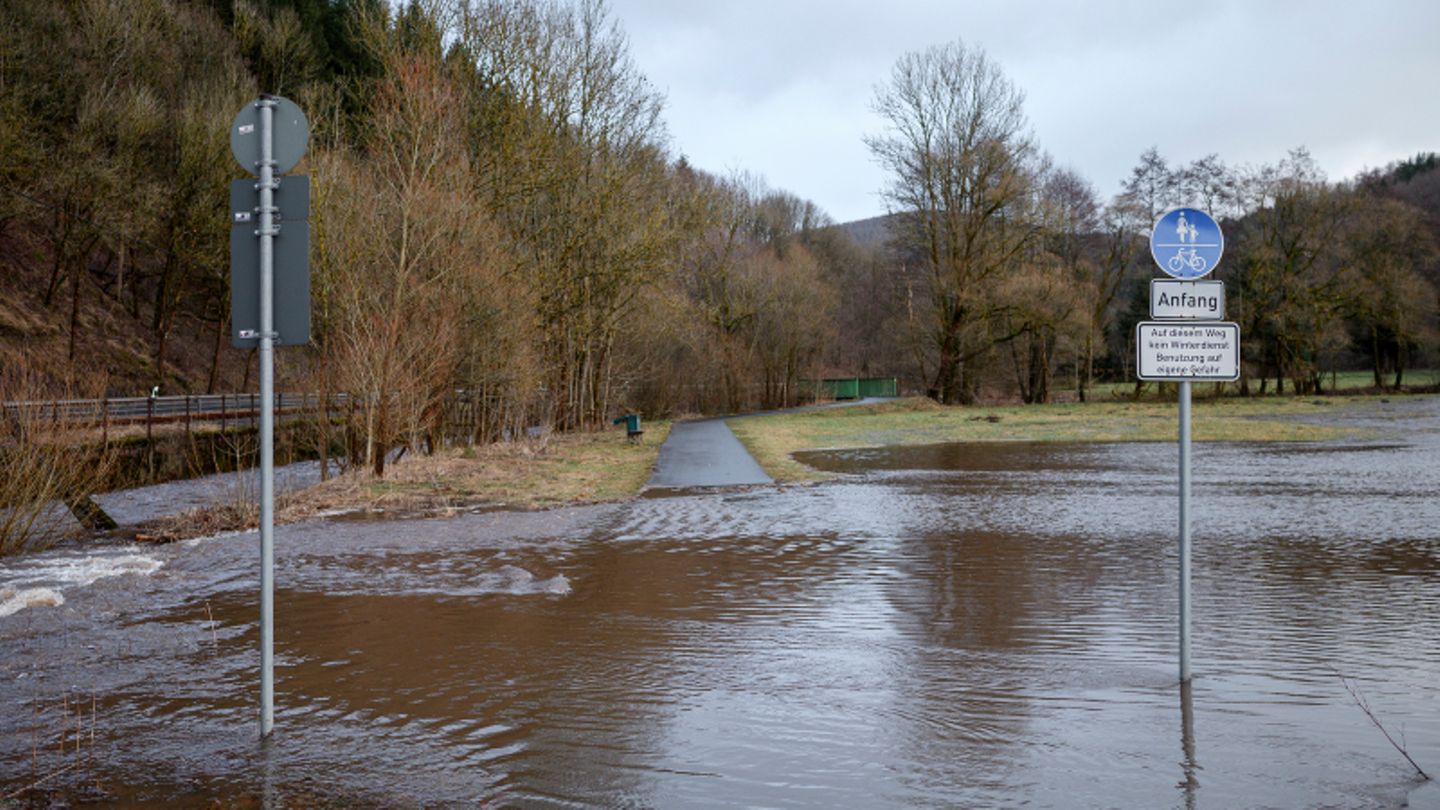 Eine überschwemmte Wiese überflutet einen Radweg