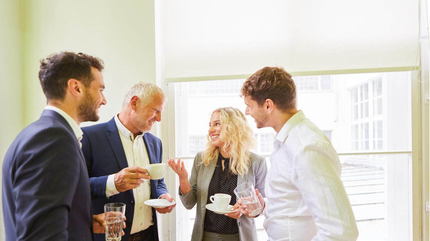 Büro-Angestellt unterhalten sich bei einer Tasse Kaffee