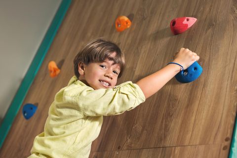 Klettersteine für Kinder: Junge an einer Indoor-Kletterwand