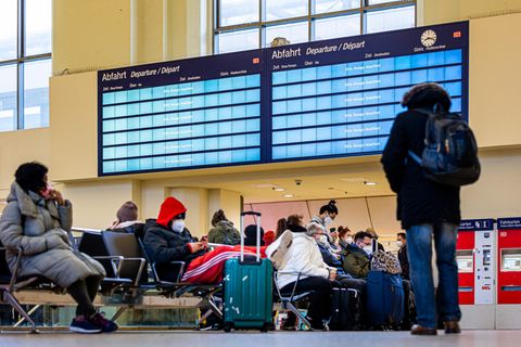 Reisende warten im Hauptbahnhof von Hannover
