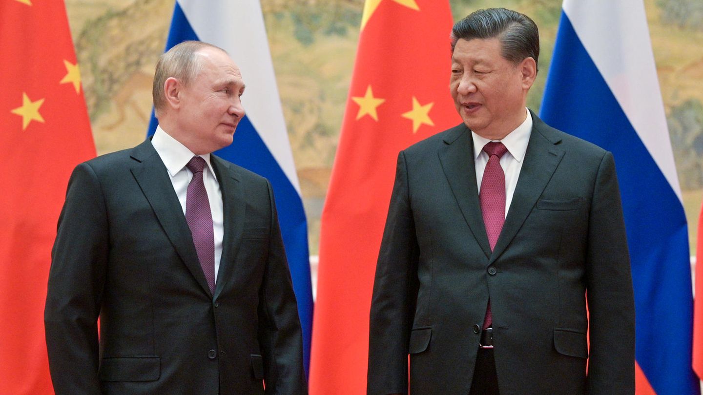 Putin und Xi Jinping vor russischen und chinesischen Flaggen Putin und Xi Jinping vor russischen und chinesischen Flaggen