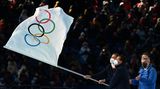 Die Bürgermeister von Mailand und Cortina d'Ampezzo, Giuseppe Scala und Gianpietro Ghedina, schwenken die olympischen Flagge, die ihnen von IOC-Chef Thomas Bach (re.) überreicht wurde. Die nächsten Winterspiele finden in vier Jahren in Italien statt.