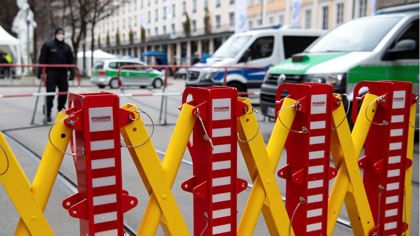 Ein Absperrgitter und Polizeiautos