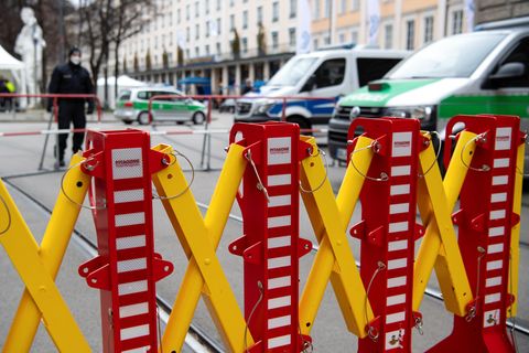 Ein Absperrgitter und Polizeiautos