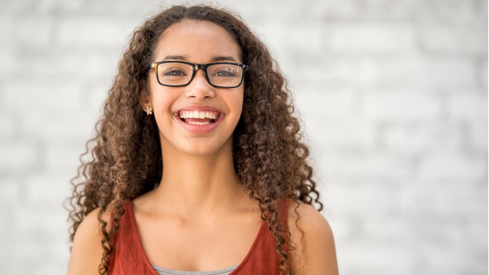 Eine junge Frau mit Brille, lachend