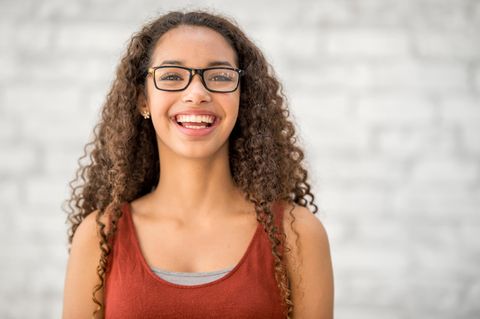 Eine junge Frau mit Brille, lachend