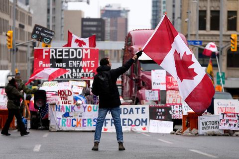 Demonstrant schwenkt Kanada Flagge vor einem parkenden Lkws in Ottawa.