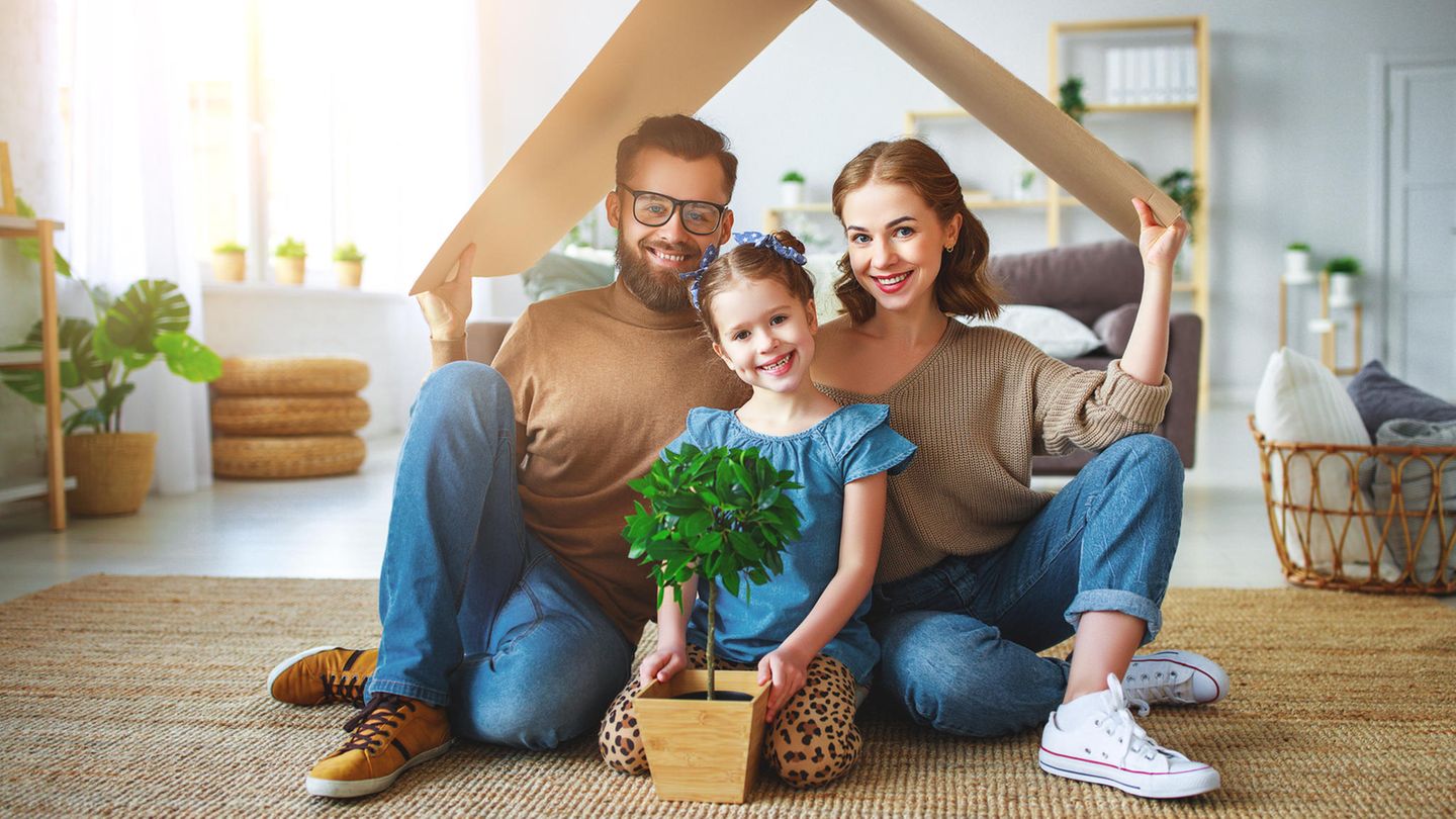 Familie sitzt unter einem Pappdach in einer Wohnung