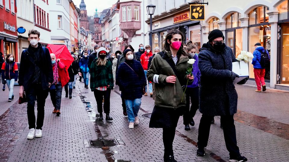 Studierende laufen bei dem Trauerzug für die Opfer Amoklaufs an der Universität durch die Heidelberger Innenstadt