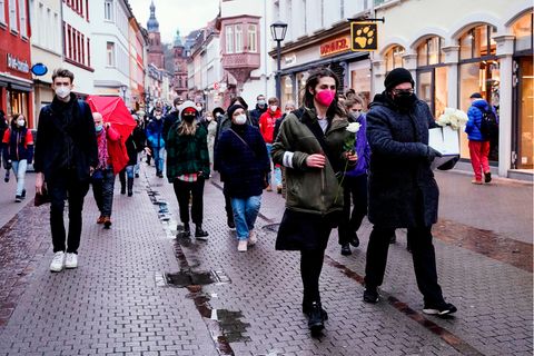 Studierende laufen bei dem Trauerzug für die Opfer Amoklaufs an der Universität durch die Heidelberger Innenstadt