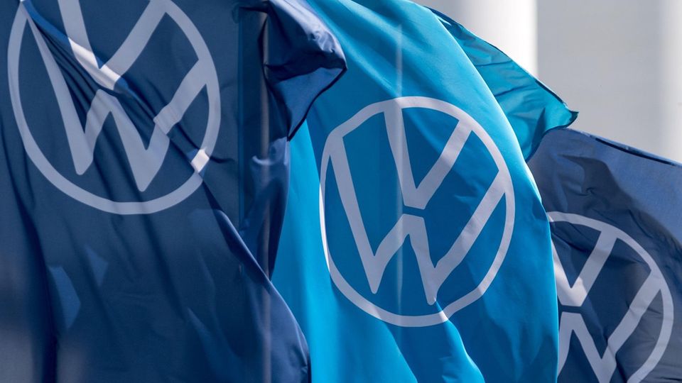 Drei Fahnen mit dem VW-Logo wehen im Wind