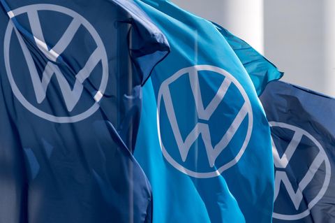 Drei Fahnen mit dem VW-Logo wehen im Wind