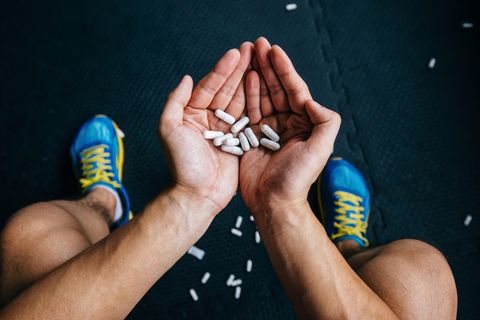 Ein Sportler hält Tabletten in den Händen