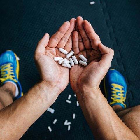 Ein Sportler hält Tabletten in den Händen