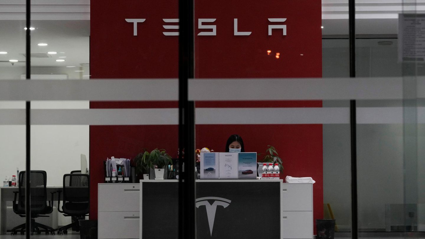 Eine Mitarbeiterin an ihrem Arbeitsplatz in einem Tesla-Showroom
